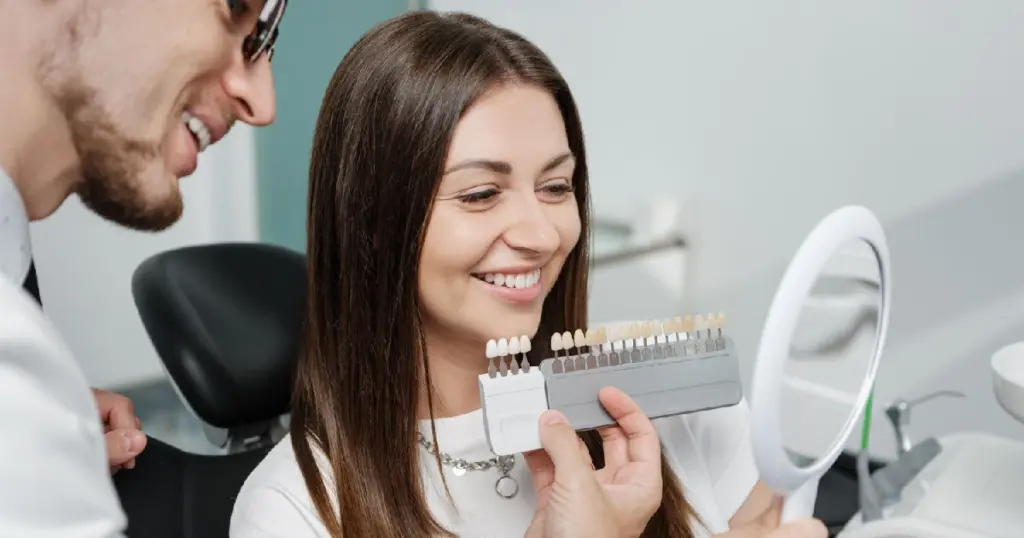 Woman consulting with dentist and comparing tooth shades for Porcelain Veneers in Allentown, PA